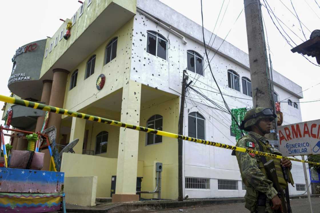 A soldier guards a town hall in southern Mexico where gunmen killed at least 20 people including the mayor A soldier guards a town hall in southern Mexico where gunmen killed at least 20 people including the mayor