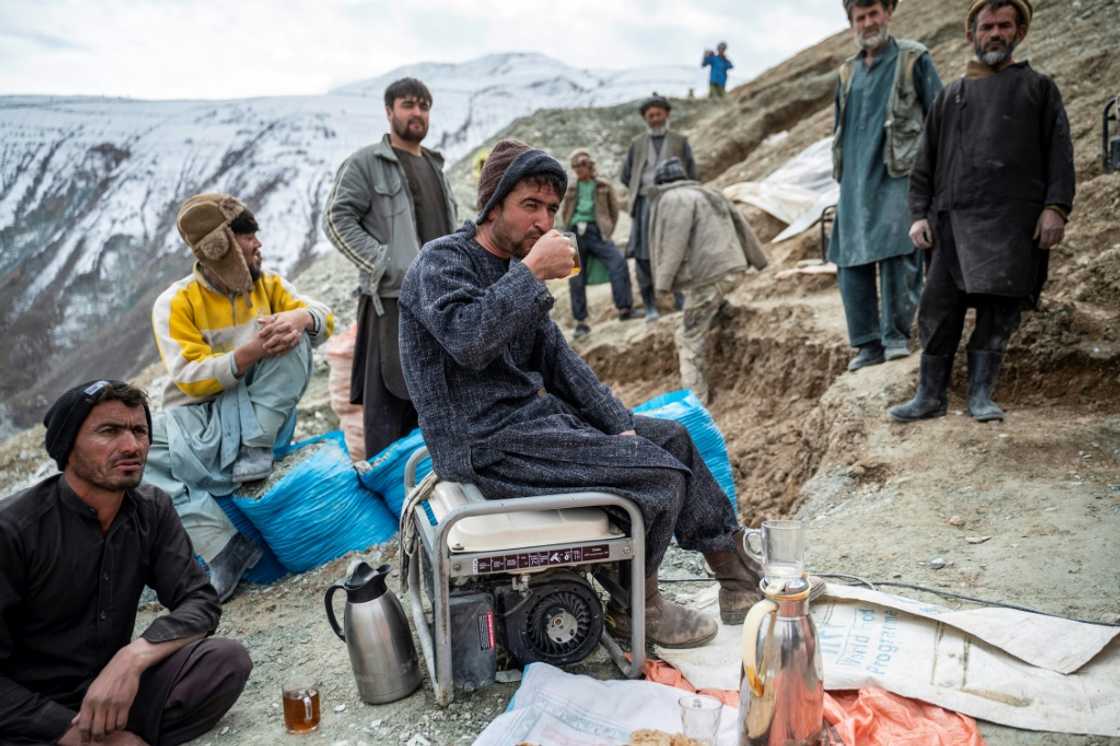 A group of Afghan miners take a break outside their gold mine A group of Afghan miners take a break outside their gold mine