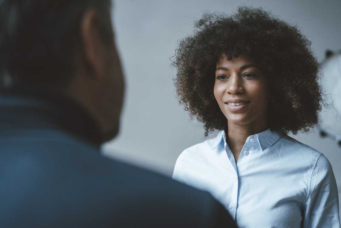 A woman talking to a man while smiling