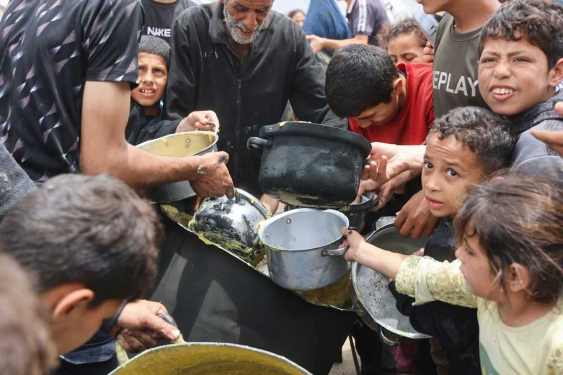 Palestinian children getting a hot food ration from a charity kitchen at the Islamic University campus in Gaza City Palestinian children getting a hot food ration from a charity kitchen at the Islamic University campus in Gaza City