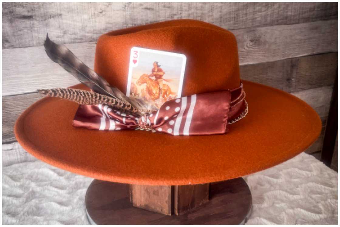 An orange-brimmed hat with embellishments An orange-brimmed hat with embellishments