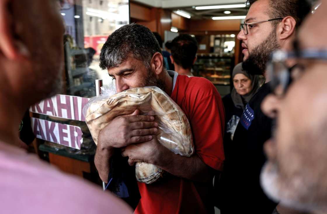 A man walks out of a bakery clutching a bag of subsidised flatbread, as others continue to queue amid a wheat shortage in crisis-hit Lebanon A man walks out of a bakery clutching a bag of subsidised flatbread, as others continue to queue amid a wheat shortage in crisis-hit Lebanon