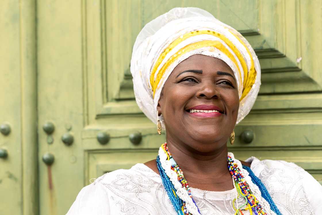An African woman smiling with traditional attire.