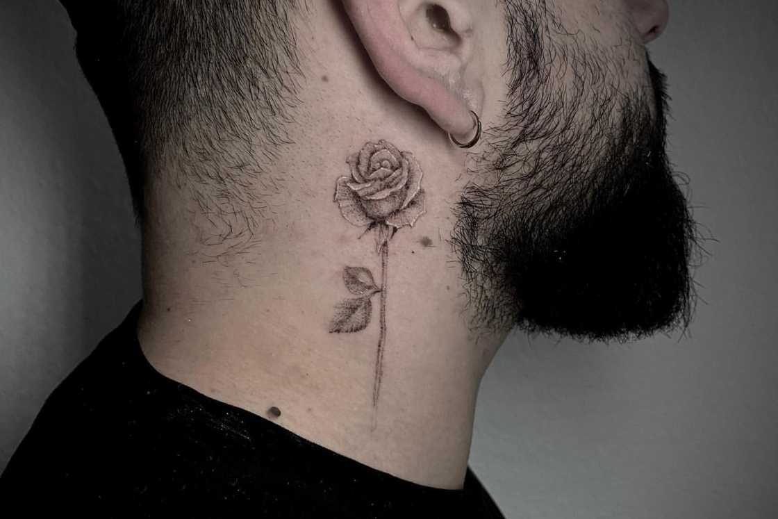 A simple black and gray neck rose tattoo A simple black and gray neck rose tattoo