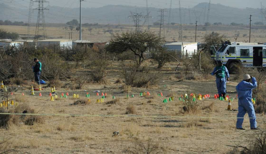 Aftermath: Police forensic experts at work the day after the massacre. A decade later, no-one has been charged over the deaths