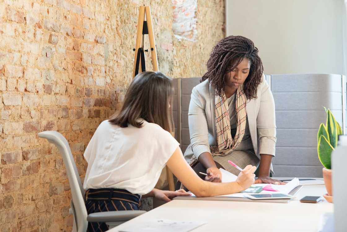 Two women reviewing documents together at the office.