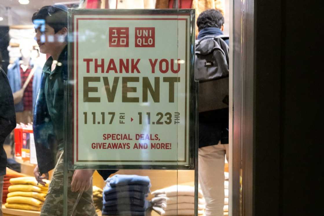 A person walks past a sales advertisement at Uniqlo Department Store at Union Station in Washington on November 21, 2023 A person walks past a sales advertisement at Uniqlo Department Store at Union Station in Washington on November 21, 2023