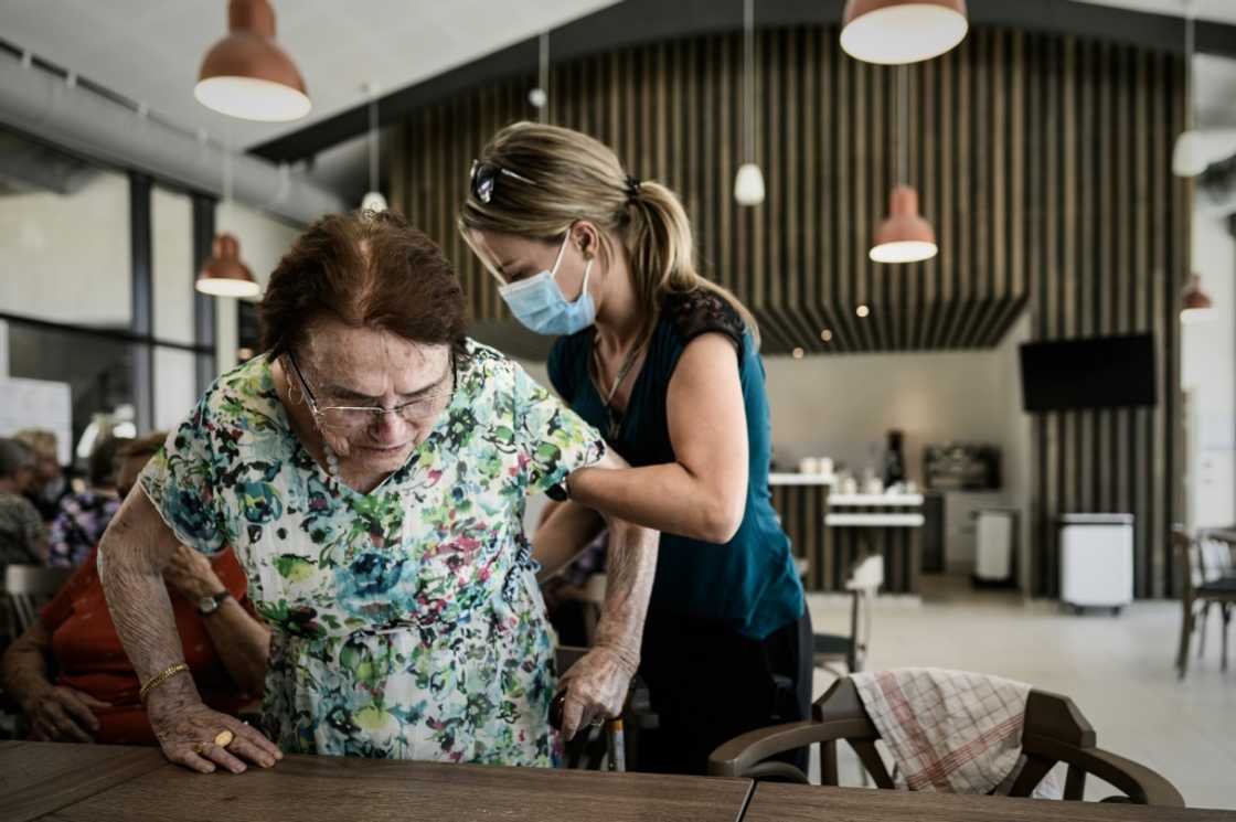 A volunteer attends to Alzheimer's patients at a center for Alzheimer's patients in Dax, southwestern France