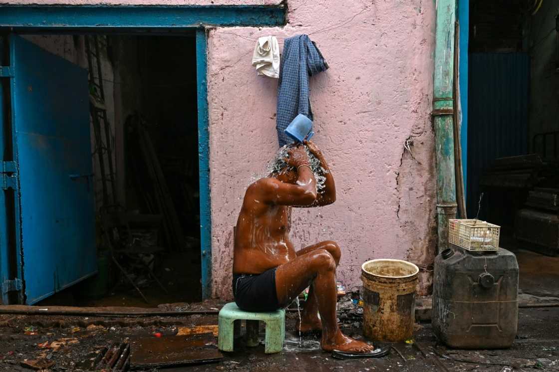 A worker bathes outside a factory in the Dharavi slums of Mumbai, where water and waste management infrastructure have not kept pace with growth A worker bathes outside a factory in the Dharavi slums of Mumbai, where water and waste management infrastructure have not kept pace with growth