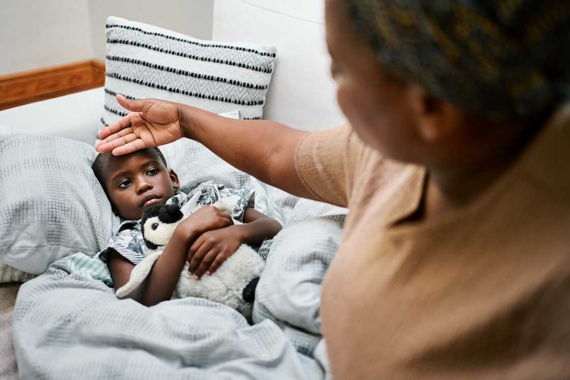 A woman checking a child's temperature A woman checking a child's temperature