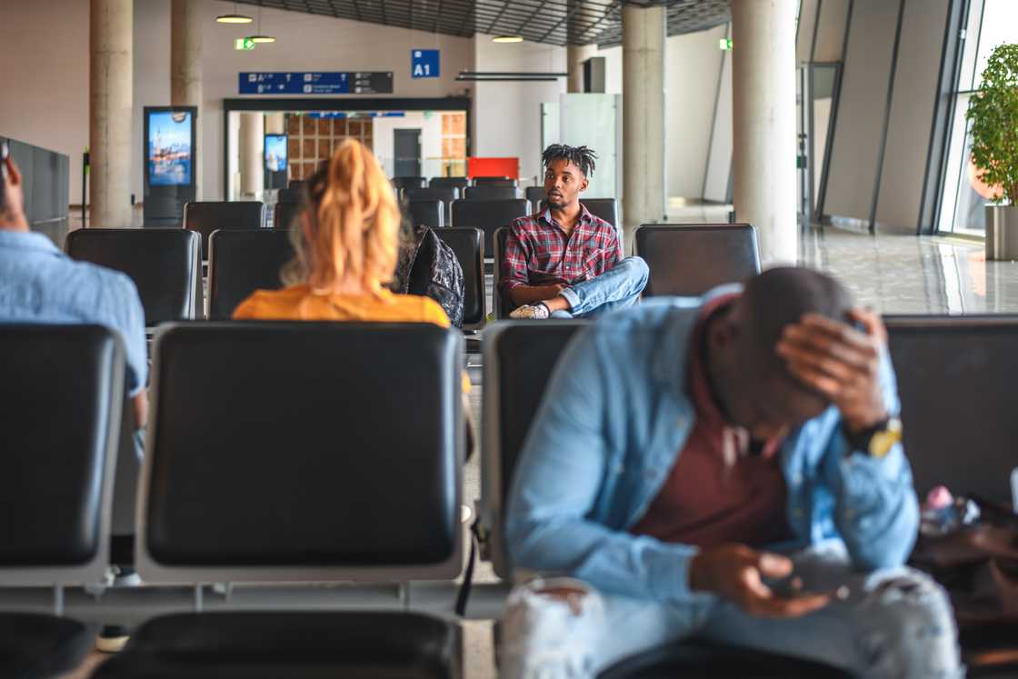 Grieving travellers, phones glowing with tragic updates.