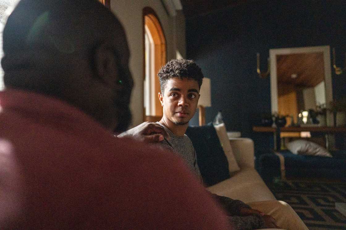 Father consoling and giving advice to son at home Father consoling and giving advice to son at home