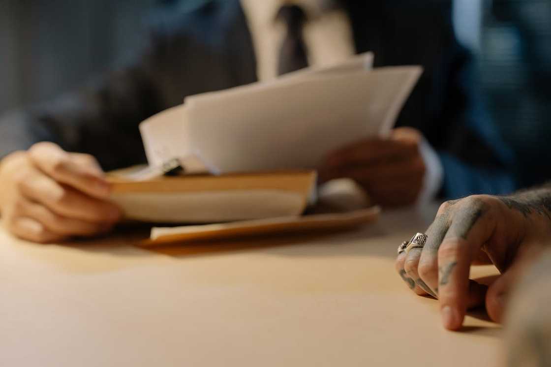 A detective looks at papers containing evidence. A detective looks at papers containing evidence.