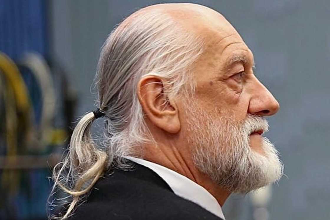 An aged man is rocking a low ponytail style An aged man is rocking a low ponytail style