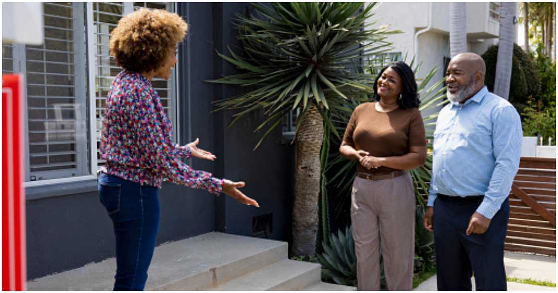 A real estate agent convincing clients to take a house A real estate agent convincing clients to take a house