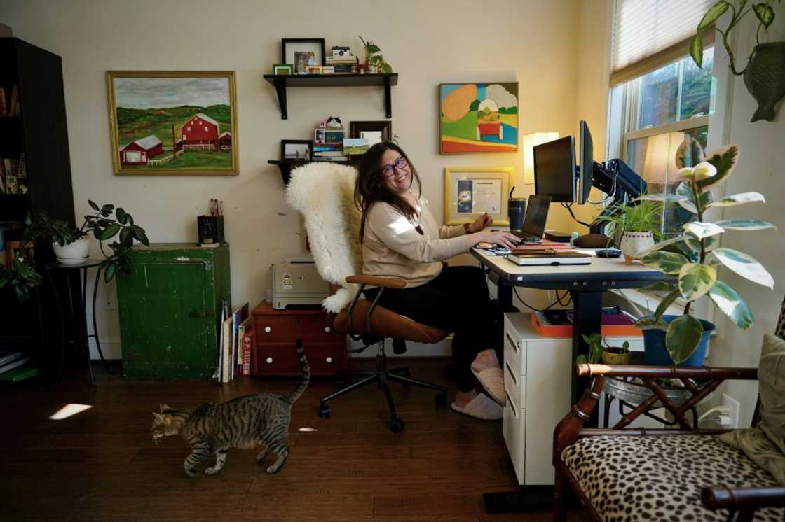 DrFirst employee Heather Happe sits at her desk next to her cat Duncan at her home in Frederick, Maryland -- she is a 14-year veteran of the company DrFirst employee Heather Happe sits at her desk next to her cat Duncan at her home in Frederick, Maryland -- she is a 14-year veteran of the company