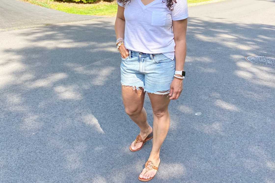 A lady is wearing a denim cutoff with a white t-shirt. A lady is wearing a denim cutoff with a white t-shirt.