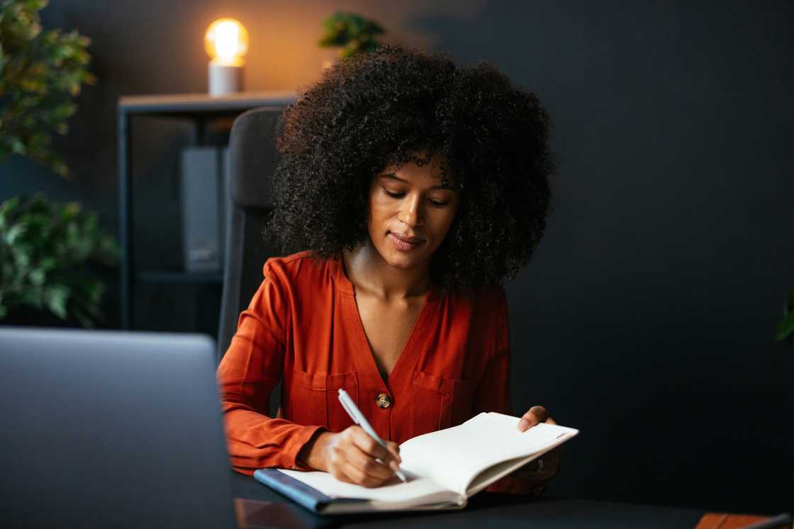 A woman writing on her journal at night.