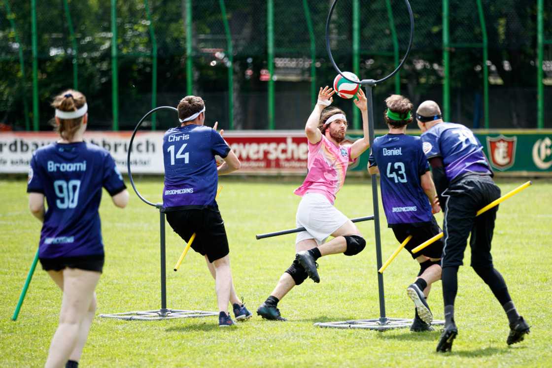 Robin Menzel throws the Quaffle through a ring to score a goal against the "Bröwicorns"