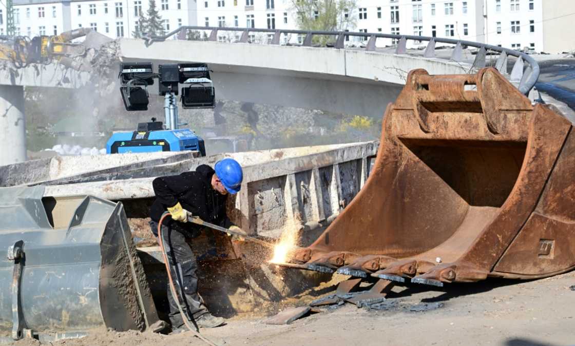 A construction worker welds part of an excavator as a bridge is being torn down in Berlin’s Charlottenburg district A construction worker welds part of an excavator as a bridge is being torn down in Berlin’s Charlottenburg district