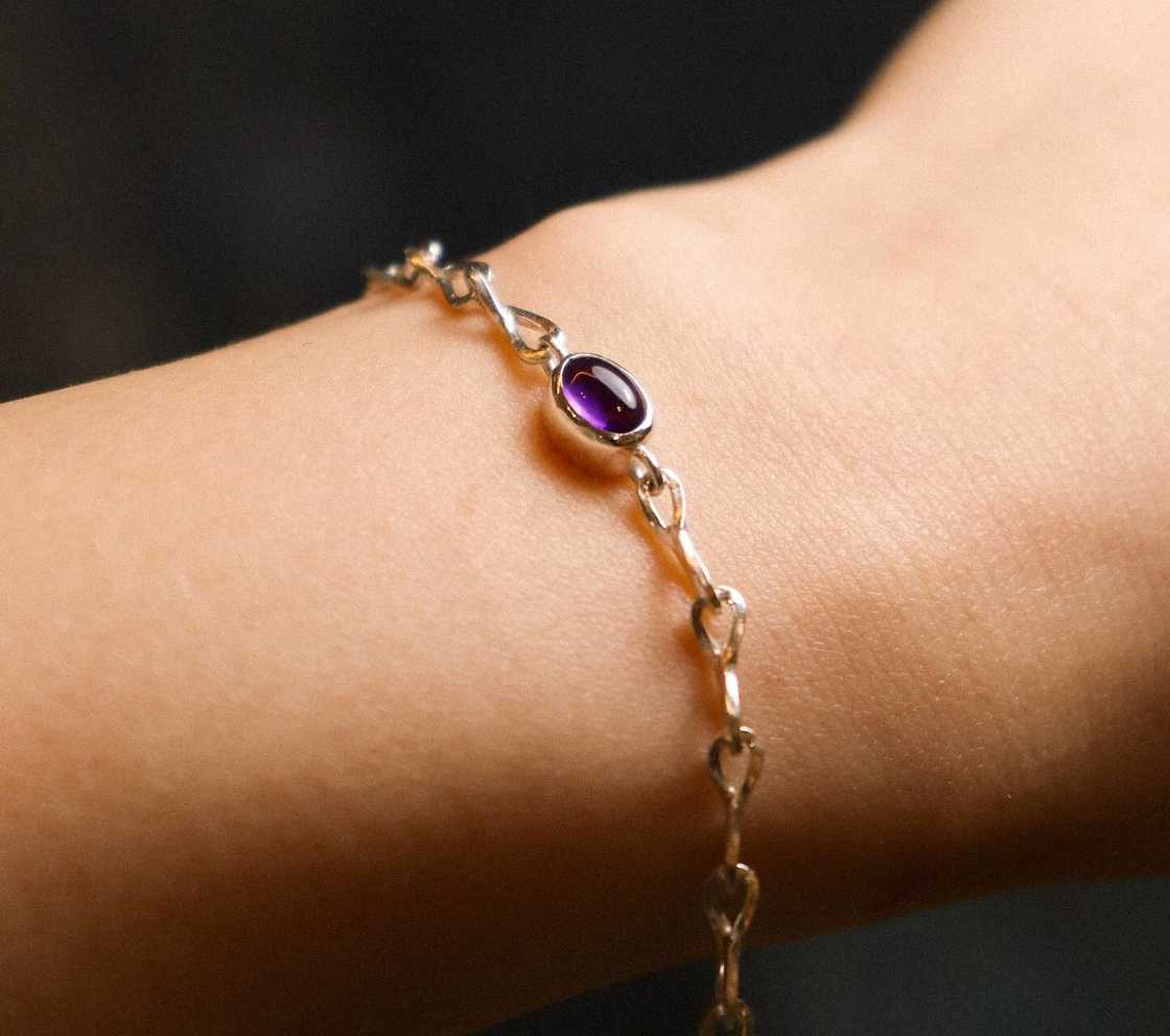 A woman wears a purple birthstone bracelet A woman wears a purple birthstone bracelet