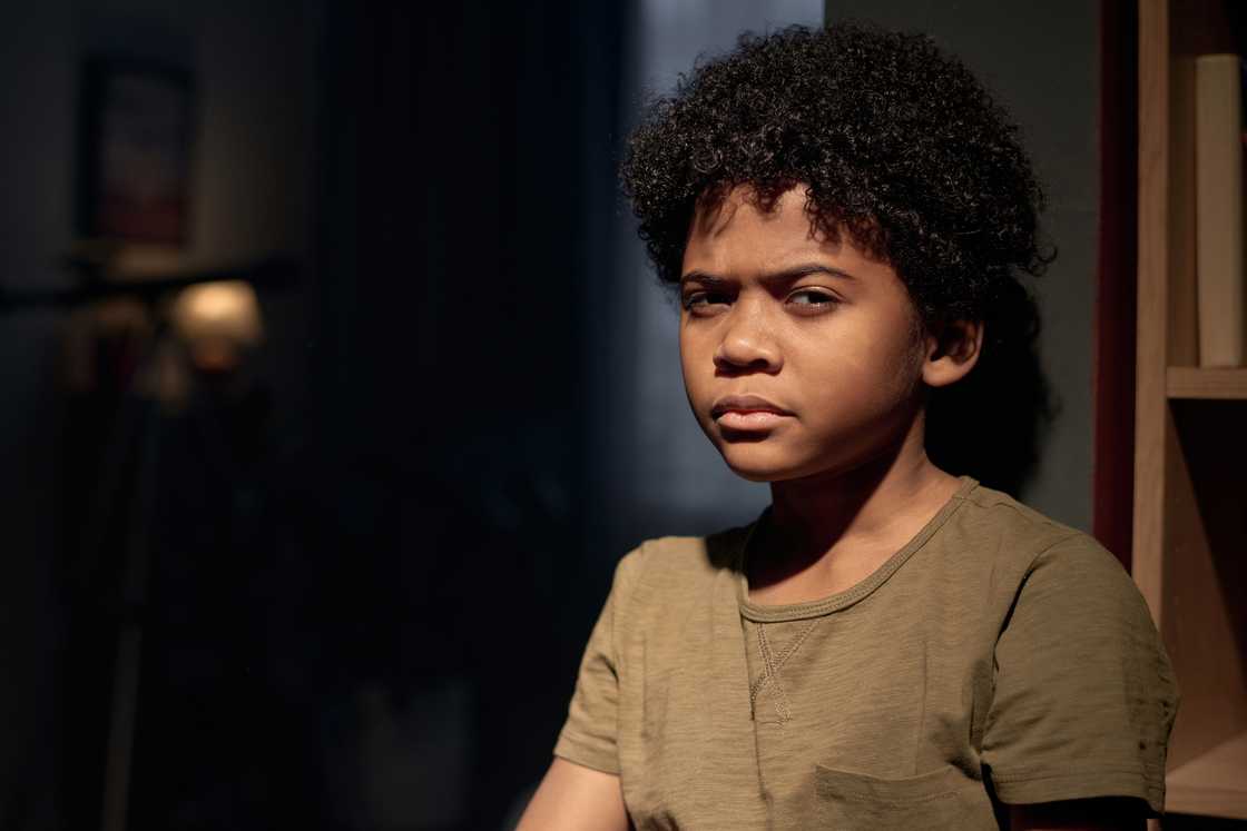 A boy looking at camera with serious face expression A boy looking at camera with serious face expression