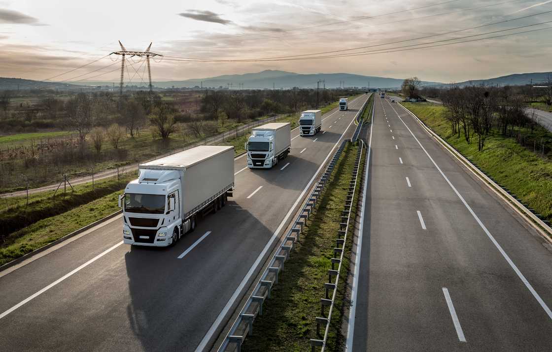 A convoy of trucks in line on a country highway A convoy of trucks in line on a country highway