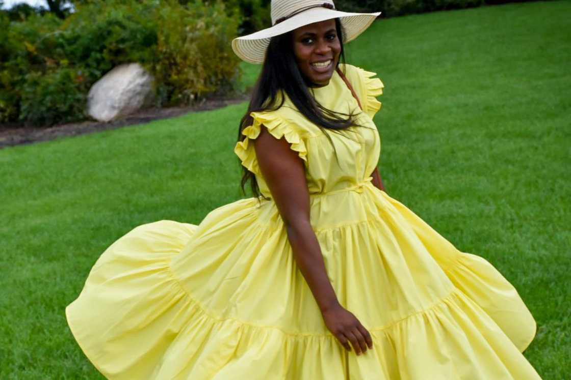 A woman is wearing a yellow skater dress A woman is wearing a yellow skater dress