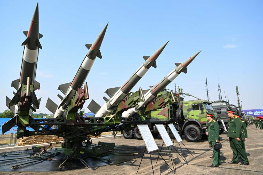 Vietnamese military officials look at an anti-aircraft missile launcher and ammunition during a defence expo in Hanoi