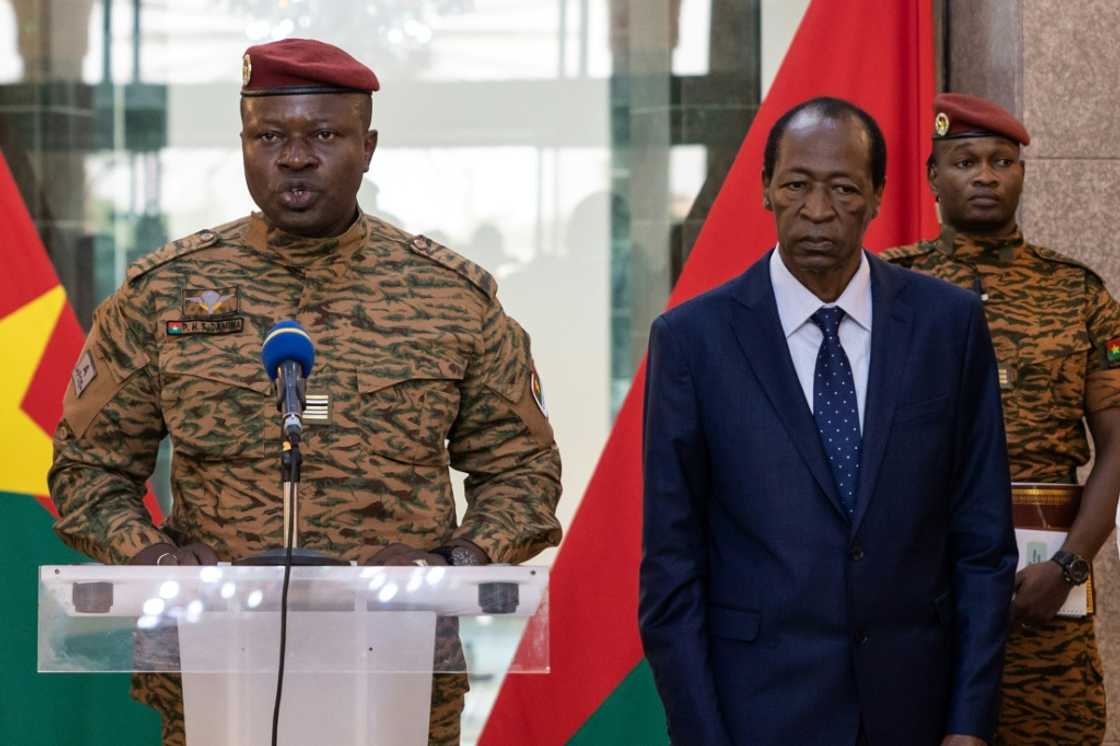 Burkina Faso's new strongman, Lieutenant-Colonel Paul-Henri Sandaogo Damiba (L), speaks flanked by former president Blaise Compaore (R) Burkina Faso's new strongman, Lieutenant-Colonel Paul-Henri Sandaogo Damiba (L), speaks flanked by former president Blaise Compaore (R)