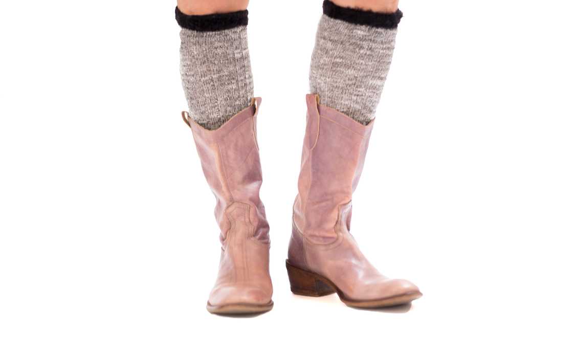 A standing lady sports a pair of boots and knee-high boot socks A standing lady sports a pair of boots and knee-high boot socks