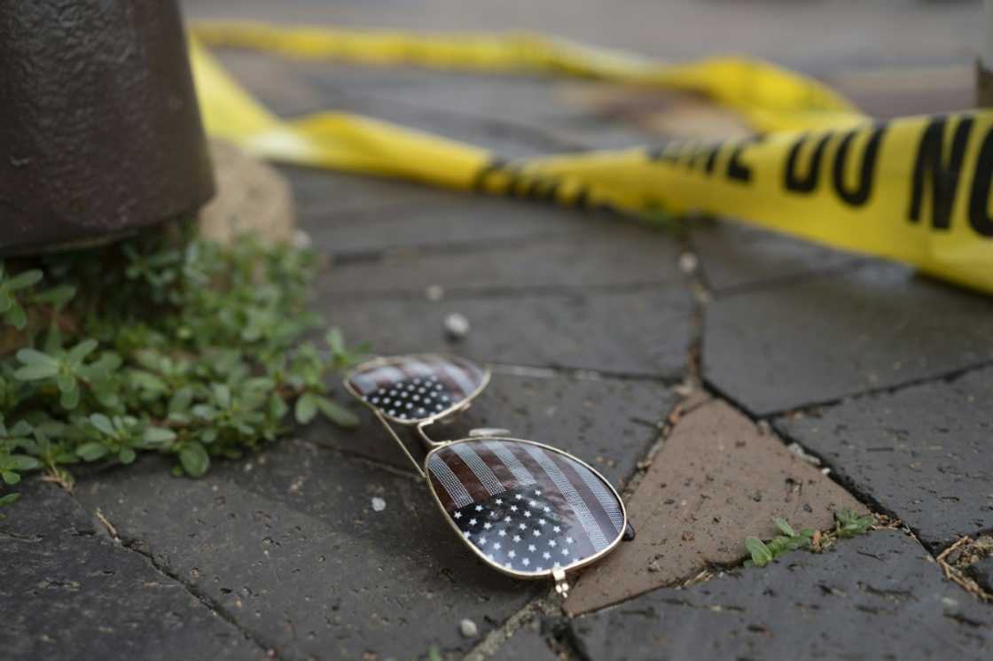Police crime tape is seen near an American flag-themed sunglasses laying on the ground at the scene of the Fourth of July parade shooting in Highland Park, Illinois on July 4, 2022 Police crime tape is seen near an American flag-themed sunglasses laying on the ground at the scene of the Fourth of July parade shooting in Highland Park, Illinois on July 4, 2022