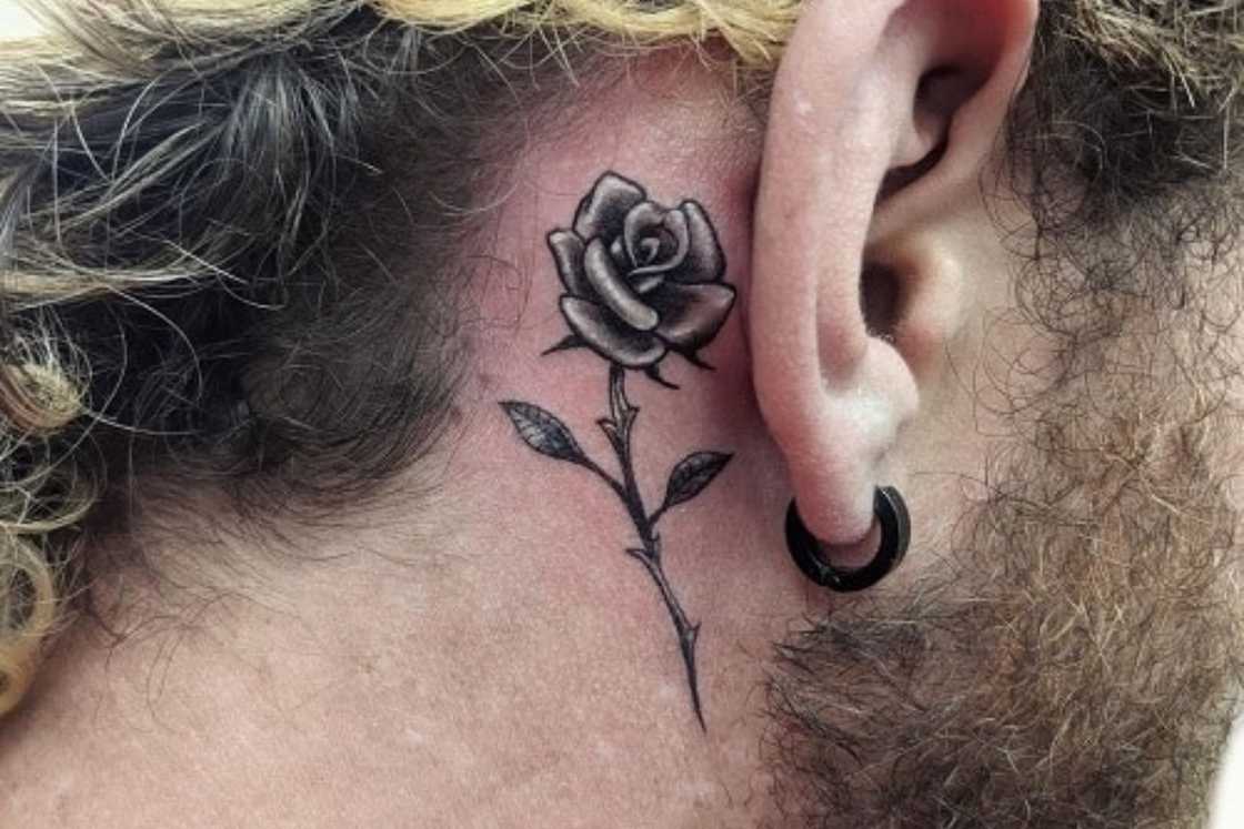 A small black and grey rose tattoo behind the ear A small black and grey rose tattoo behind the ear