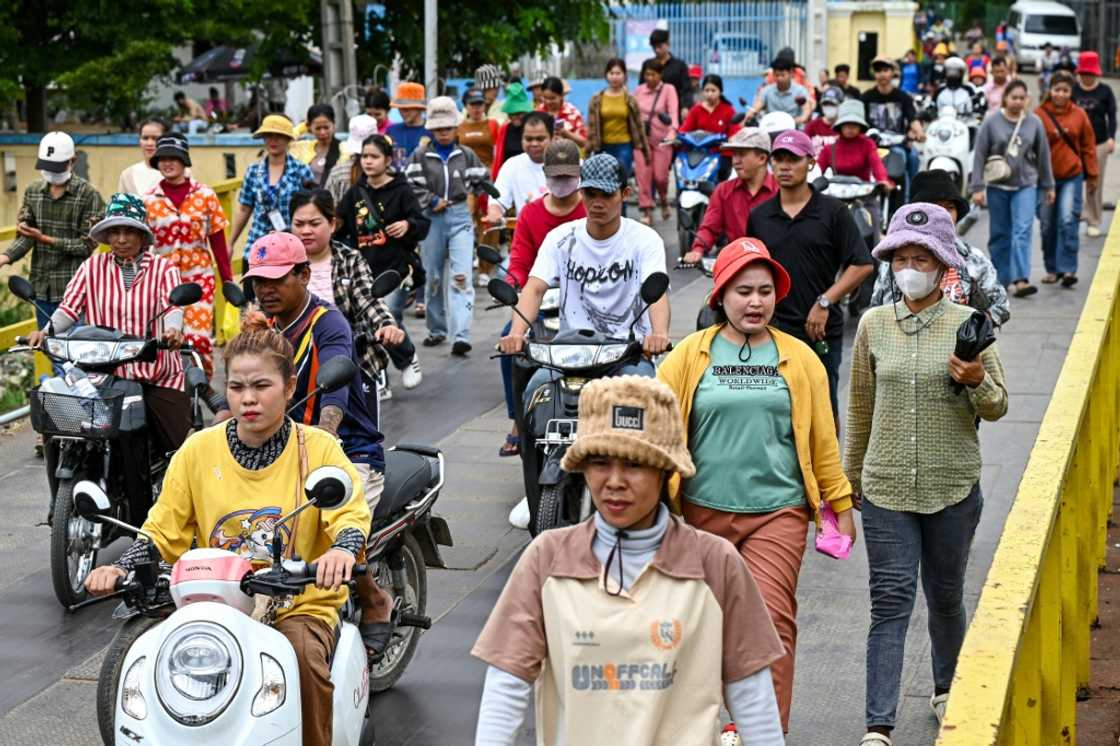Cambodian garment workers walk out of their factory during their lunch break in Phnom Penh Cambodian garment workers walk out of their factory during their lunch break in Phnom Penh