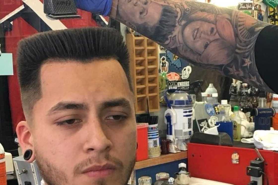 A man is at the barbershop getting a flat-top haircut with shaved sides A man is at the barbershop getting a flat-top haircut with shaved sides