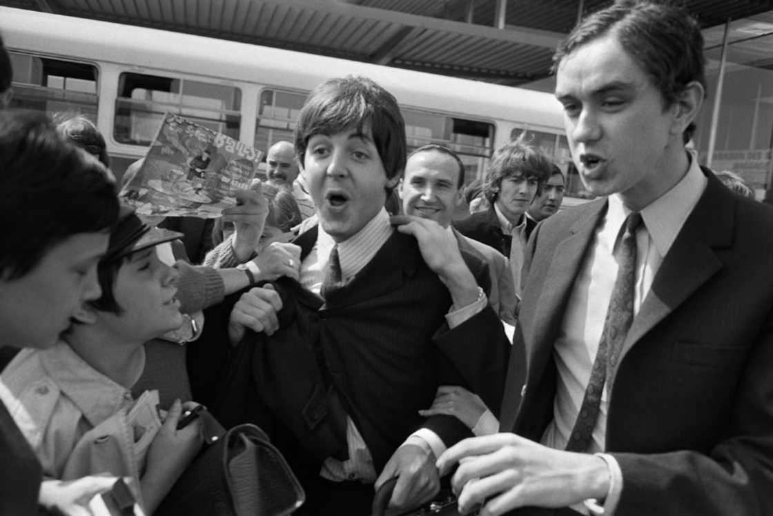 Fans surround the Beatles' members Paul McCartney (C) and George Harrison (2nd R) at their arrival at Orly airport on June 20, 1965, before their concert at the Palais des Sports the same evening Fans surround the Beatles' members Paul McCartney (C) and George Harrison (2nd R) at their arrival at Orly airport on June 20, 1965, before their concert at the Palais des Sports the same evening