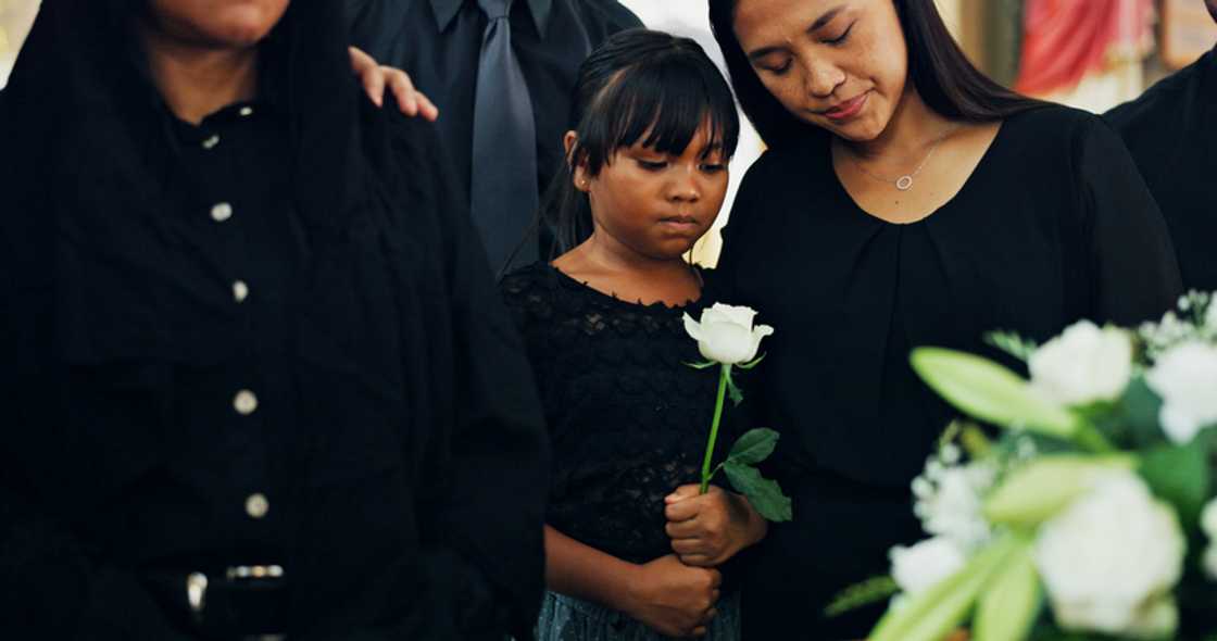 Two women stand apart at a funeral in Accra.