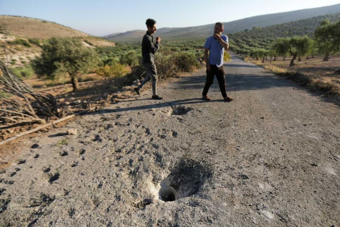 People inspect the site where a US drone targeted killed Maher al-Agal, a leader in the Islamic State militant group near Jindires in northern Syria.