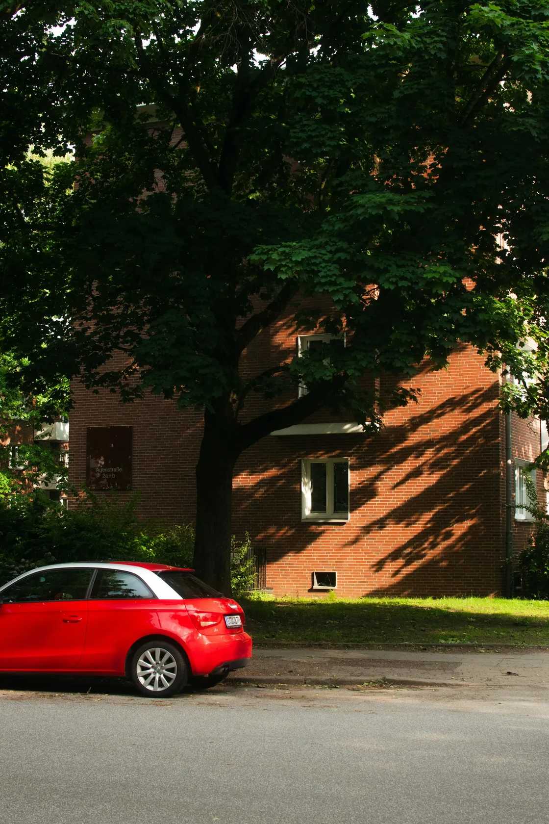 Red car near the buiding Red car near the buiding