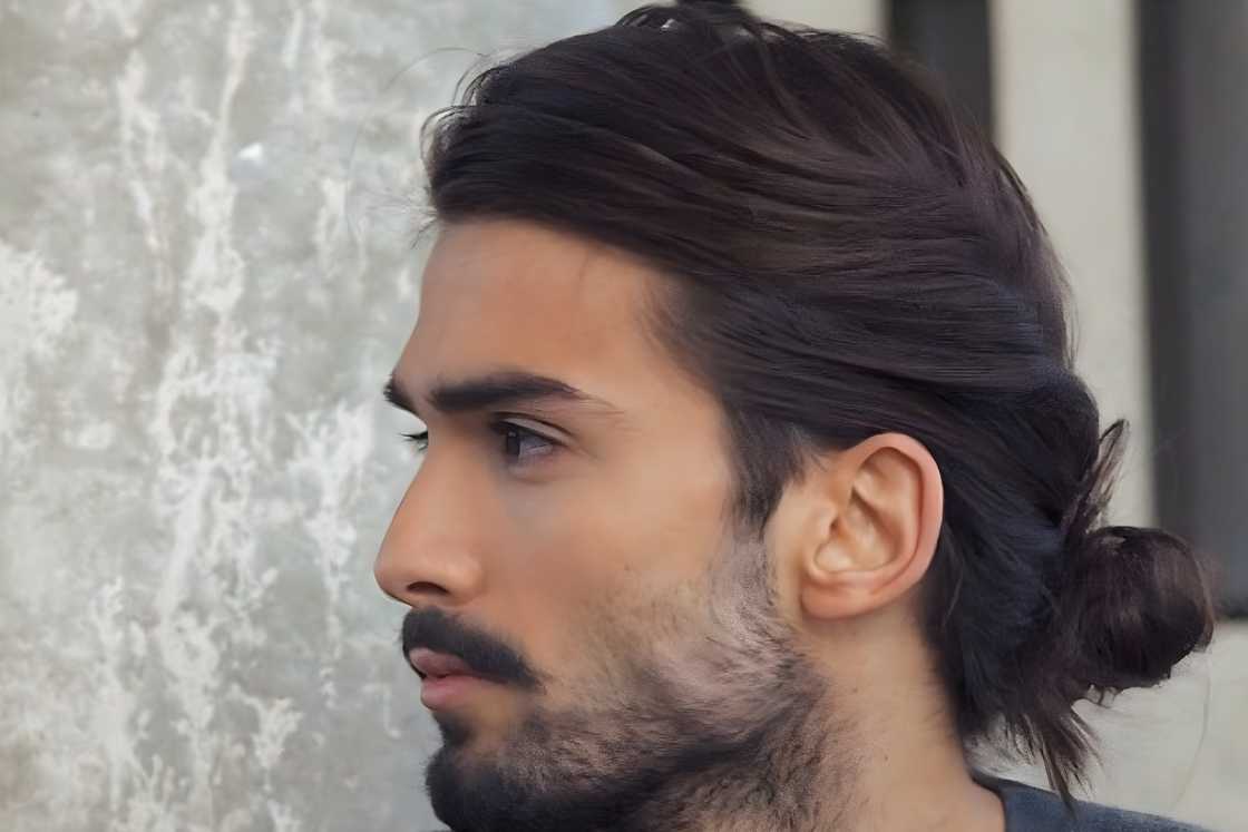 A man is wearing a twisted low bun hairstyle A man is wearing a twisted low bun hairstyle