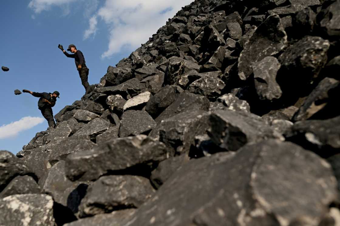 Workers sort coal near a coal mine in Datong, China's northern Shanxi province on November 2, 2021 Workers sort coal near a coal mine in Datong, China's northern Shanxi province on November 2, 2021