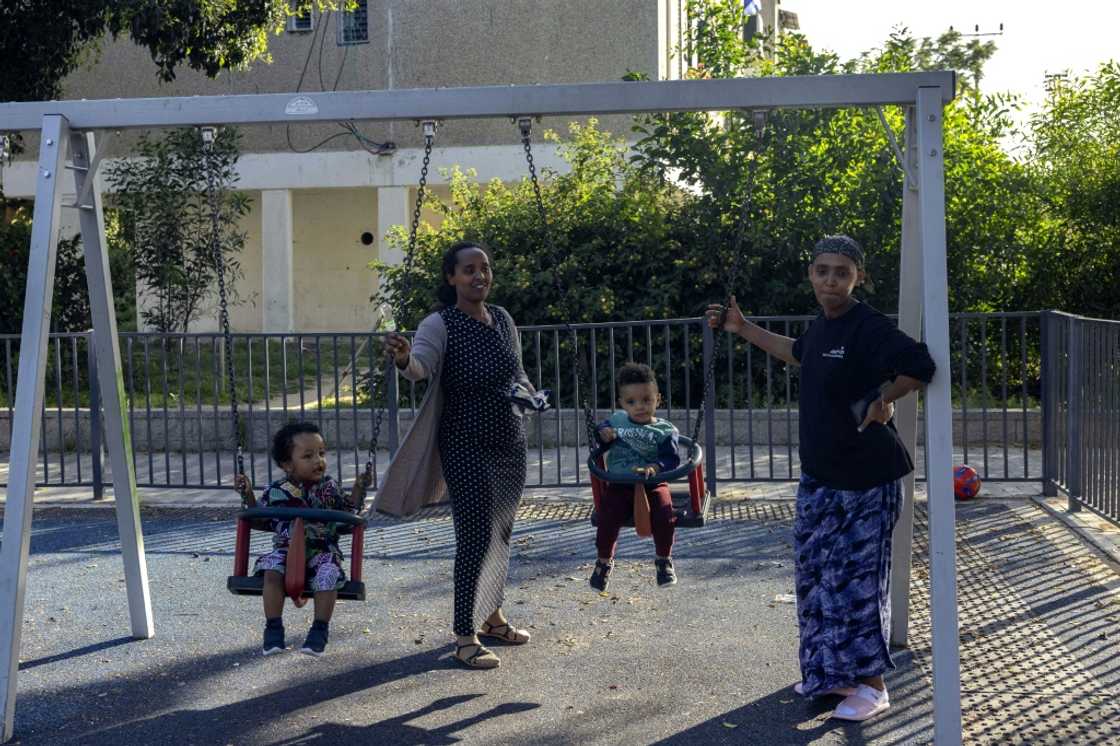 Women swing children at a playground in Ashkelon Women swing children at a playground in Ashkelon