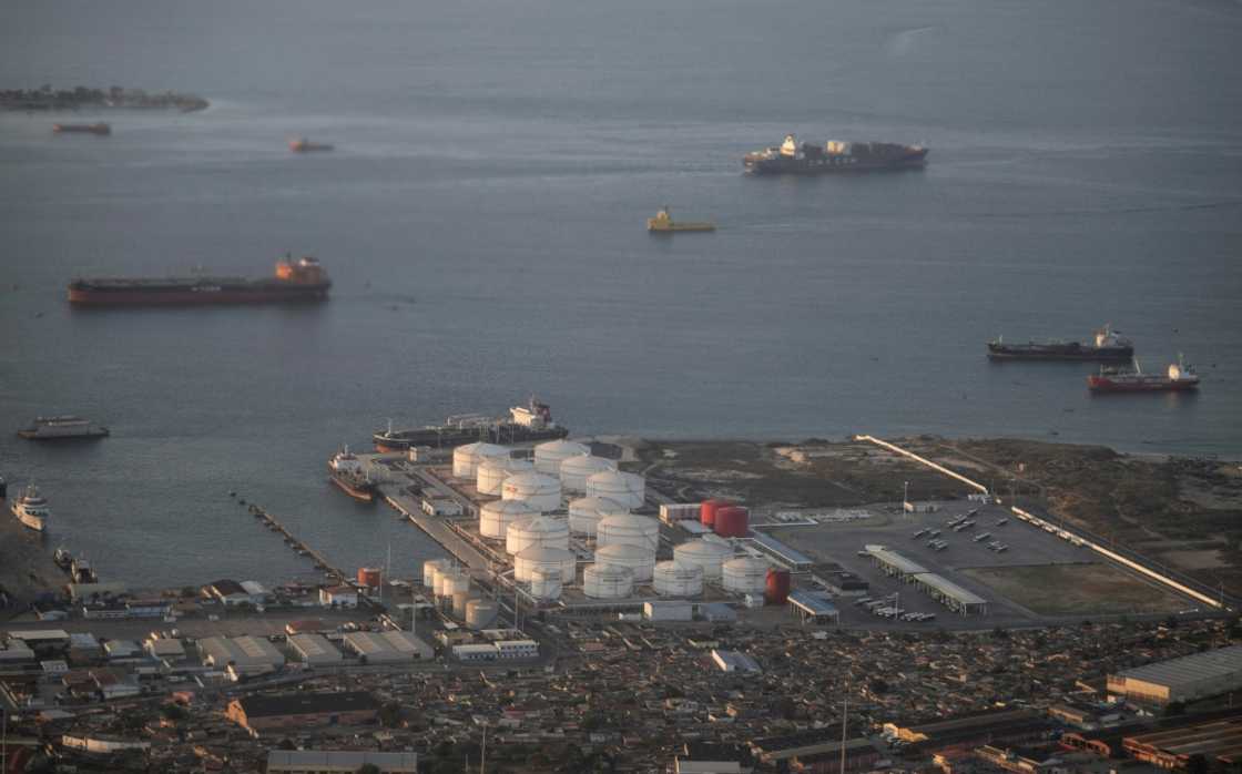 Cargo ships outside an oil and gas storage facility at a port in Luanda, the capital of Angola