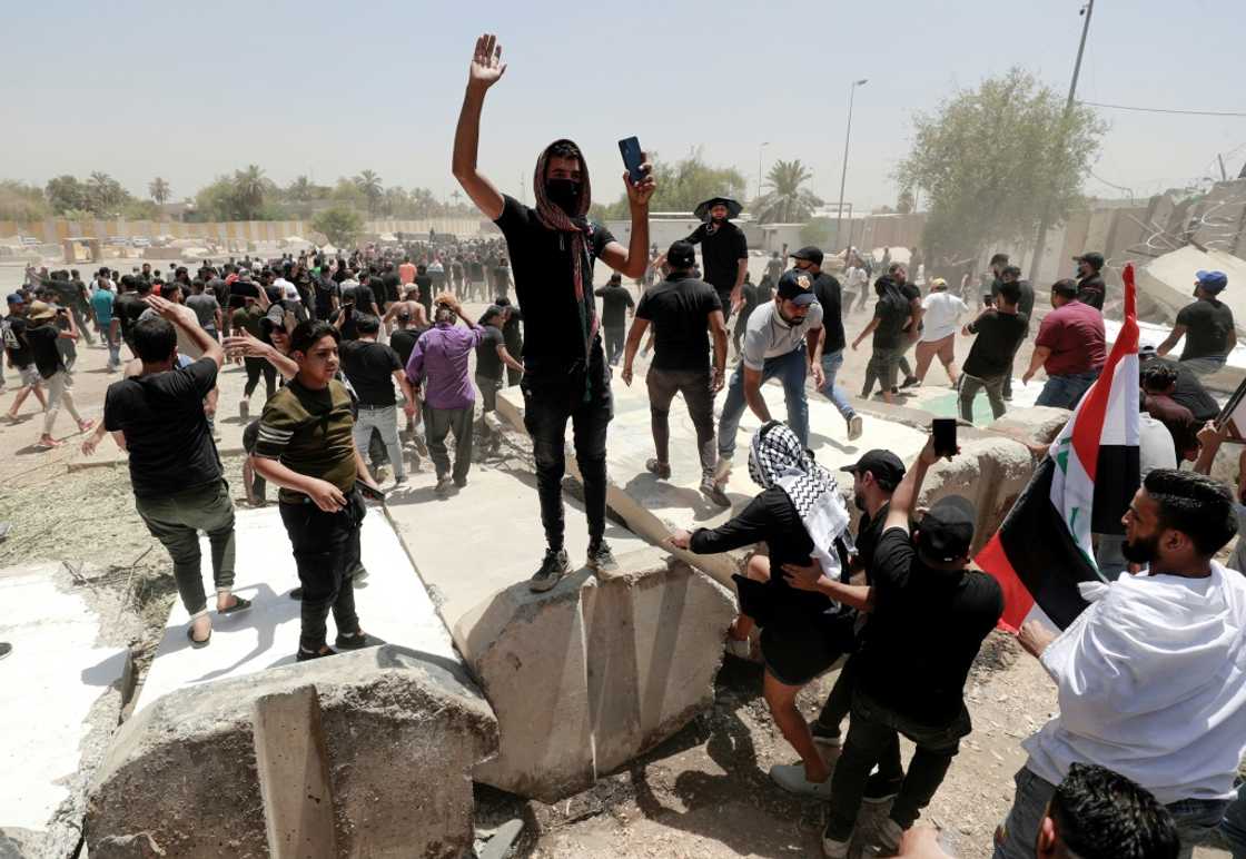 Supporters of the Iraqi cleric Moqtada Sadr celebrate after bringing down concrete barriers leading to the capital Baghdad's high-security Green Zone and the country's parliament