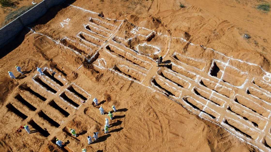 An aerial view shows Libyan experts exhuming human remains from mass graves in Tarhuna, southeast of the capital Tripoli, on October 28, 2020