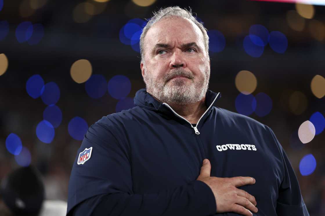 Mike McCarthy stands on the sidelines during the national anthem