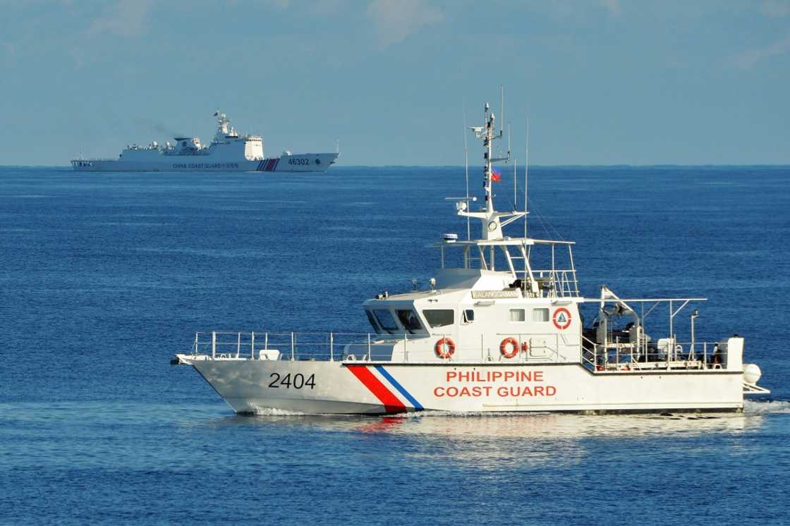 A Philippines coast guard ship (R) sails past a Chinese coast guard ship near Scarborough Shoal in the South China Sea in 2019 A Philippines coast guard ship (R) sails past a Chinese coast guard ship near Scarborough Shoal in the South China Sea in 2019