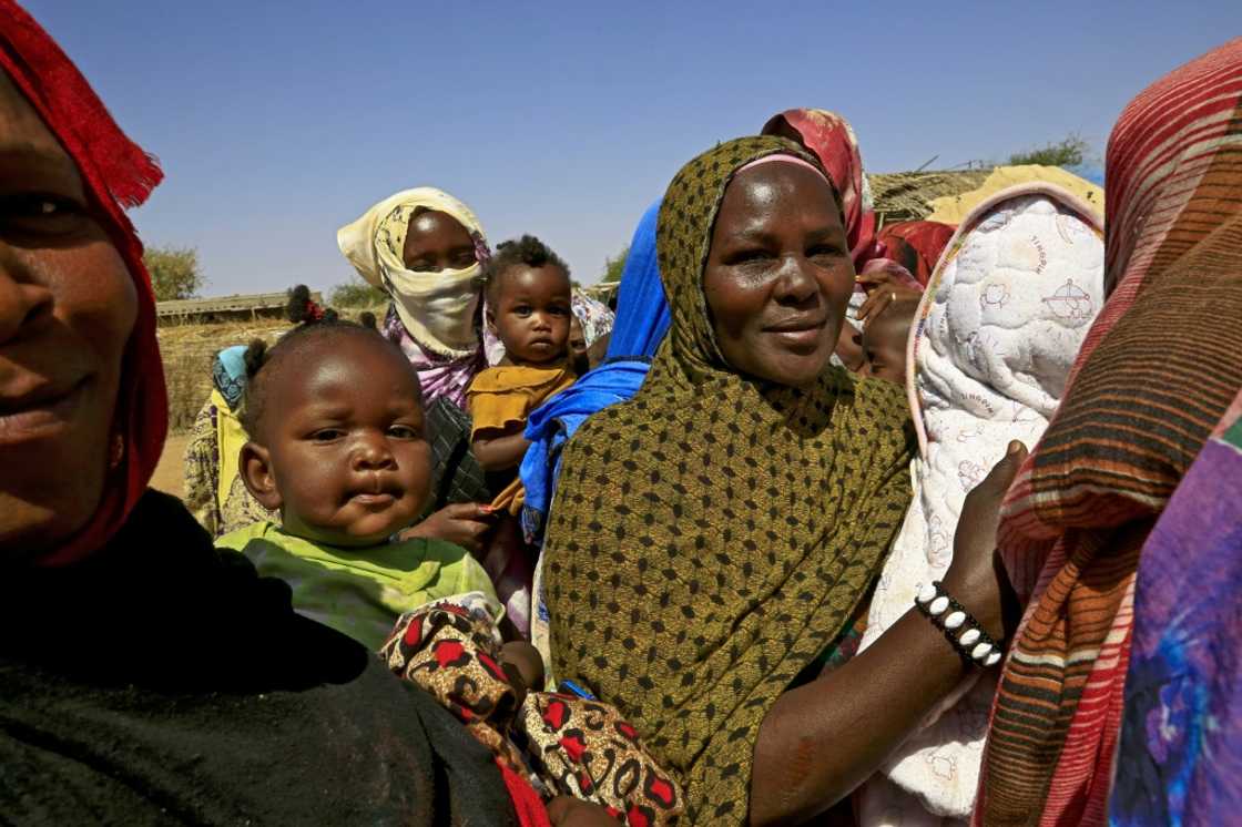 Increasing demands on dwindling natural resources has fuelled inter-ethnic conflicts in Sudan: here Sudanese women wait for the arrival of World Food Programme (WFP) aid at a camp for displaced people in South Darfur in February 2021 Increasing demands on dwindling natural resources has fuelled inter-ethnic conflicts in Sudan: here Sudanese women wait for the arrival of World Food Programme (WFP) aid at a camp for displaced people in South Darfur in February 2021