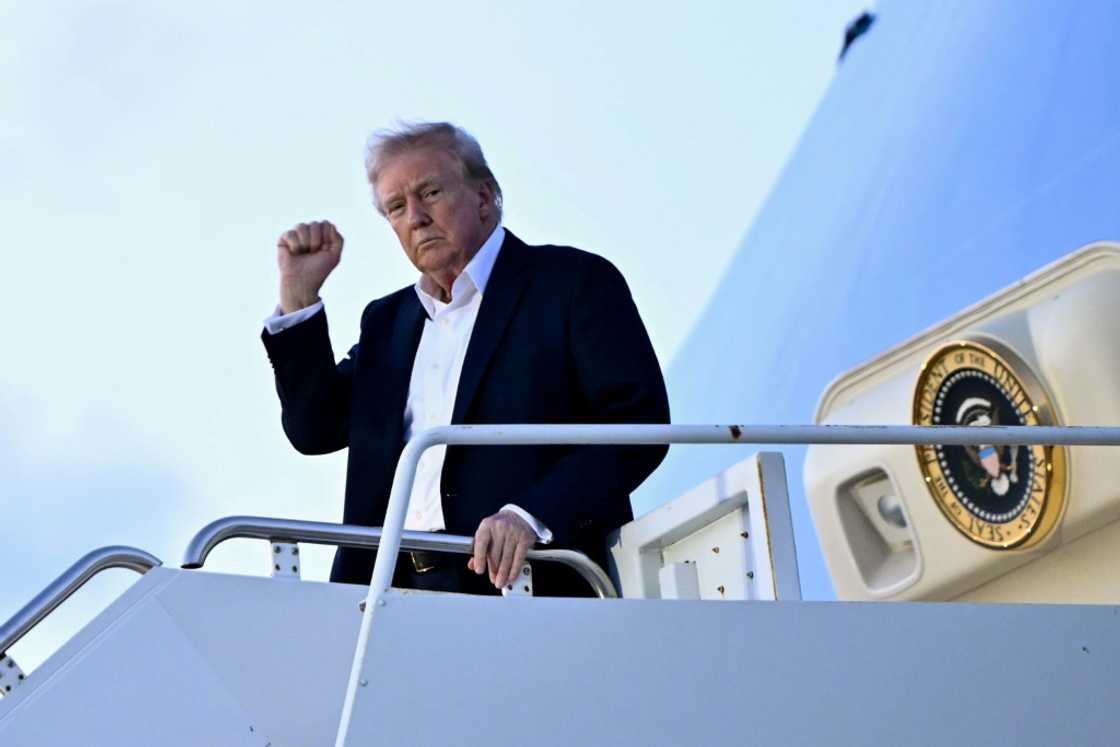 US President Donald Trump raises a fist as he steps off Air Force One at Palm Beach International Airport in Florida on April 11, 2025, while heading to spend the weekend at his Mar-a-Lago resort US President Donald Trump raises a fist as he steps off Air Force One at Palm Beach International Airport in Florida on April 11, 2025, while heading to spend the weekend at his Mar-a-Lago resort