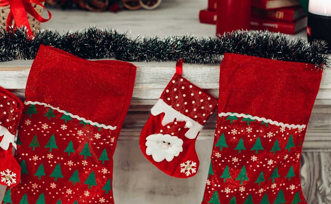 Three red and green Christmas stockings are mounted on the wall.